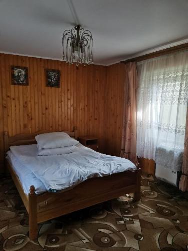 a bedroom with a bed and a chandelier at У вуйка Івана in Yaremche
