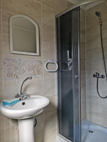 a bathroom with a sink and a shower with a mirror at У вуйка Івана in Yaremche