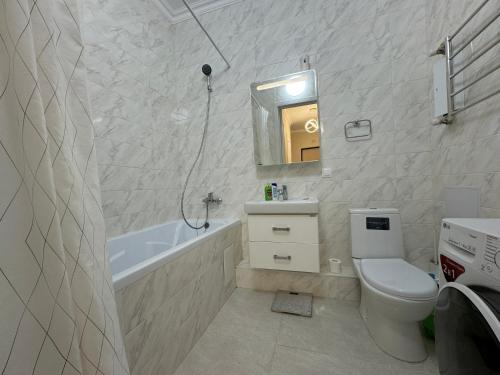 ein Badezimmer mit Toilette, Badewanne und Waschbecken in der Unterkunft Трехкомнатные бизнес апартаменты в ЖК Заман in Atyrau