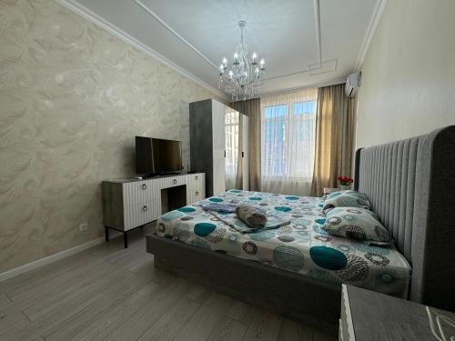 ein Schlafzimmer mit einem Bett und einem Fernseher darin in der Unterkunft Трехкомнатные бизнес апартаменты в ЖК Заман in Atyrau