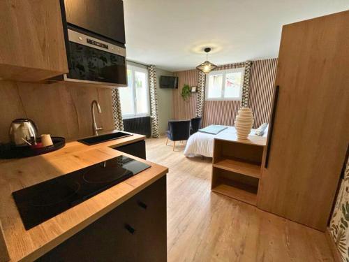 a kitchen and living room with a bed in a room at Hôtel La Rencluse in Luchon