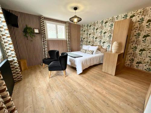 a bedroom with a bed and a chair at Hôtel La Rencluse in Luchon