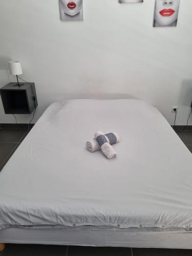 un lit blanc avec un animal rembourré dans l'établissement Appartement avec terrasse, à Montpellier