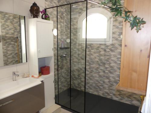 une douche avec une porte vitrée dans une salle de bain dans l'établissement Proche de Bordeaux et Saint Emilion, maison au calme avec grand jardin, à Salleboeuf