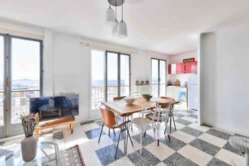 un salon avec une table, des chaises et une télévision dans l'établissement T4 exceptionnel vue sur mer à 5 min à pied du métro, à Marseille