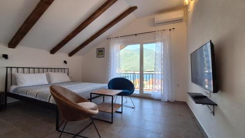 a bedroom with a bed and a chair and a window at Seaside Village in Kamenari