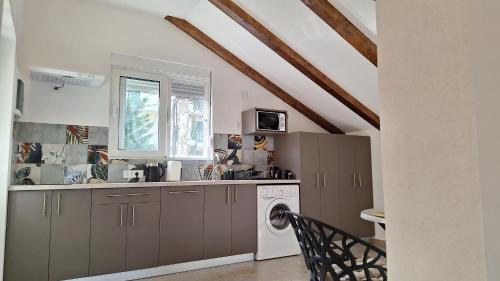 a kitchen with a washing machine and a window at Seaside Village in Kamenari