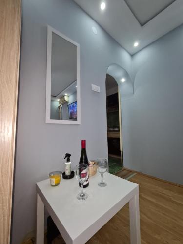 a white table with wine glasses and a mirror at Stan na Dan Nice Pozarevac in Požarevac