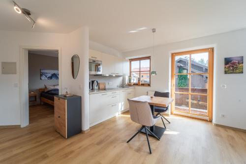 a kitchen and dining room with a table and chairs at Am Sonneneck - DreiGipfelblick Fewo6 mit Sauna in Ruhpolding