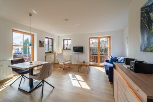 a living room with a table and a couch at Am Sonneneck - DreiGipfelblick Fewo6 mit Sauna in Ruhpolding