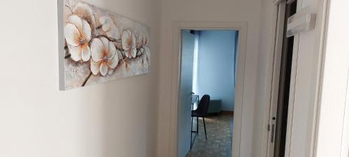 a hallway with a painting of flowers on the wall at Casa Elena in Pieve di Cadore