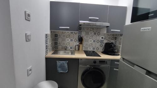 une cuisine avec un évier et une machine à laver dans l'établissement belle de mai marseille centre studio, à Marseille