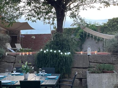 a patio with tables and chairs and a tree at Can Paulí in Ultramort