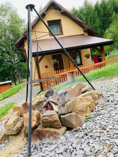 a fire pit in front of a house at Domek na Wzgórzu in Zahoczewie