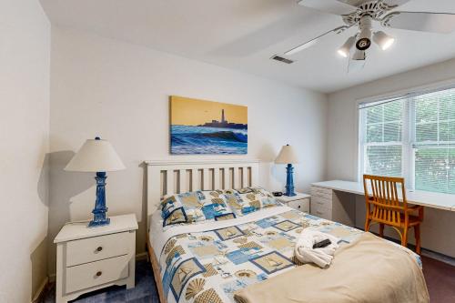 a bedroom with a bed and a desk and a window at Savannahs Landing - 6 Mary Elizabeth in Ocean View