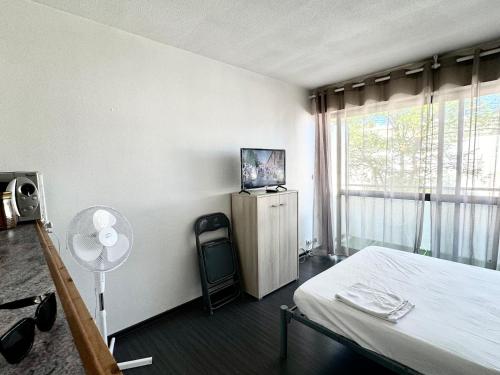 - une chambre avec un lit et une fenêtre avec un ventilateur dans l'établissement Appartement La Rochelle, à La Rochelle