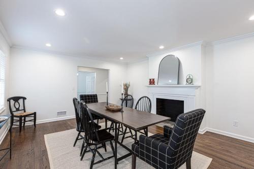 a dining room with a table and chairs and a fireplace at Group Getaway 6BR Near Fort Benning Huge Kitchen Private Yard in Columbus