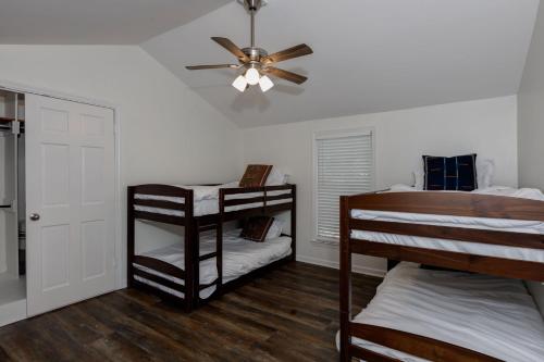 a bedroom with two bunk beds and a ceiling fan at Group Getaway 6BR Near Fort Benning Huge Kitchen Private Yard in Columbus