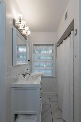 a white bathroom with a sink and a shower at Group Getaway 6BR Near Fort Benning Huge Kitchen Private Yard in Columbus
