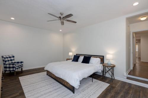 a white bedroom with a bed and a ceiling fan at Group Getaway 6BR Near Fort Benning Huge Kitchen Private Yard in Columbus