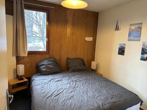 Ce lit se trouve dans un dortoir doté d'une fenêtre et d'un lit sidx sidx. dans l'établissement Les Marguerites, à Enchastrayes