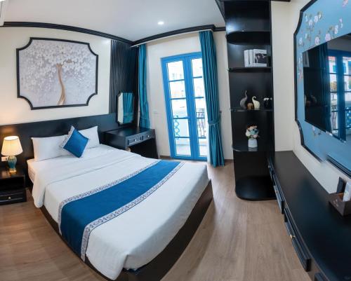 une chambre avec un grand lit et une télévision à écran plat dans l'établissement Biệt Thự Gần Biển Bãi Cháy Và Bãi Marina, à Hạ Long