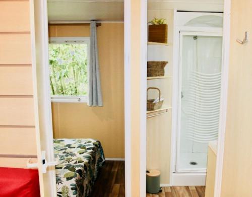 une petite pièce avec un lit et une fenêtre dans l'établissement Mobil Home Cosy, à Saint-Chéron