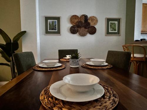 a dining room table with bowls and plates on it at Your Home Away from Home! in Kissimmee