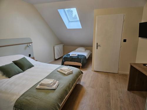 a bedroom with two beds and a skylight at Charme au milieu de l'histoire in Autun