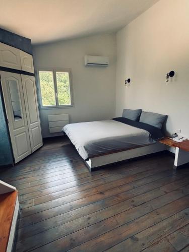 une chambre avec un lit et un parquet dans l'établissement Grande villa à 15 min des plages, à Porto-Vecchio