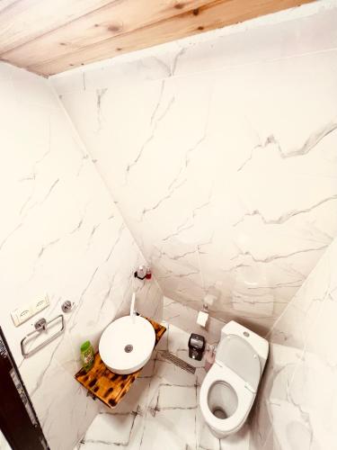 a bathroom with a toilet and a sink at Wayside Cottage in Batumi