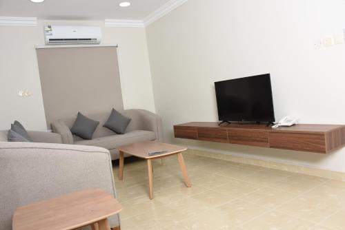 un soggiorno con divano e TV a schermo piatto di حلول سكني للشقق المخدومه a Al Ahsa