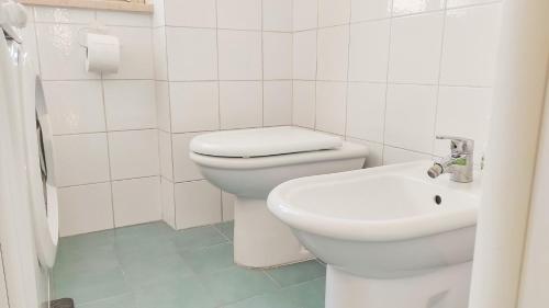 a white bathroom with a toilet and a sink at Casa Mazzini - Camera matrimoniale in centro in Pescara
