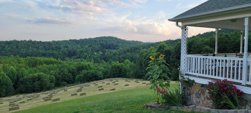 eine Veranda eines Hauses mit Blick auf ein Feld in der Unterkunft Mountain Retreat house to Relax and Enjoy in Lenoir