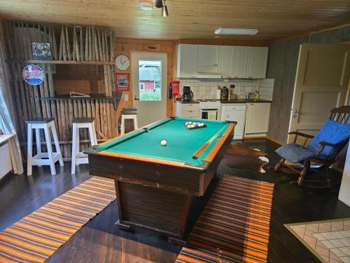 a kitchen with a pool table in a living room at Vanha myllärin torppa in Sulkava
