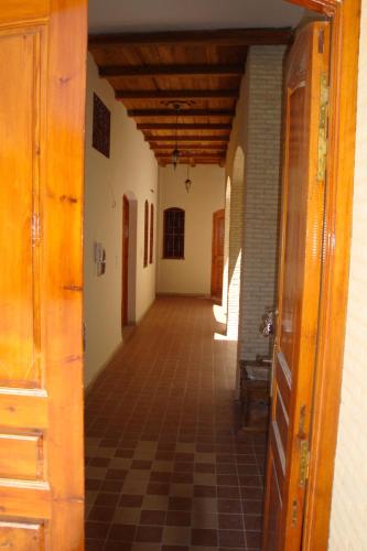 an empty hallway of a building with a tile floor at Residence Tozeur Almadina in Tozeur