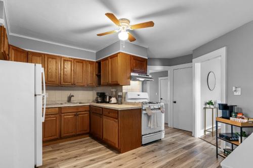 a kitchen with wooden cabinets and a ceiling fan at 2BR Apartment Near Downtown Stamford I Pets OK in Stamford