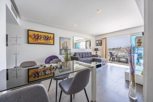 a living room with a glass table and chairs at NEW Duplex penthouse w breathtaking views by SF HOMES in Il-Gżira