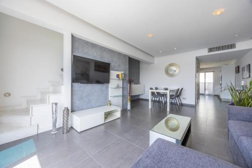 a living room with a couch and a table at NEW Duplex penthouse w breathtaking views by SF HOMES in Il-Gżira