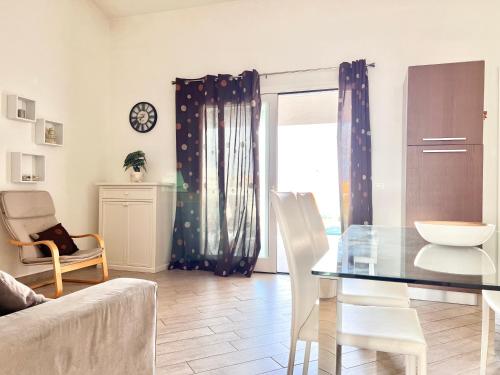 a living room with a glass table and chairs at Villa Etienne - Key to Villas in Valledoria