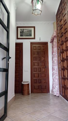 a hallway with a wooden door and a window at Casa Rural del Guadalora in Hornachuelos