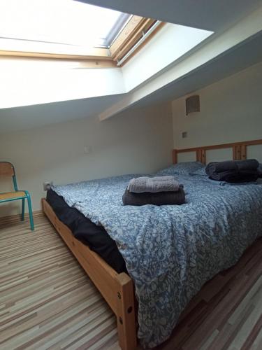 une chambre avec un grand lit avec une lucarne dans l'établissement Villa au calme 6 à 8 pers avec jacuzzi et salle fitness, à Gigean