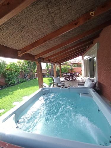un bain à remous dans une arrière-cour avec un toit dans l'établissement Villa au calme 6 à 8 pers avec jacuzzi et salle fitness, à Gigean