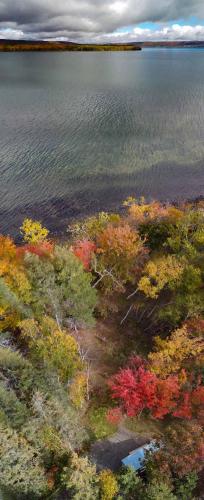an aerial view of a lake with colorful trees at Tiny Loon and Mayfly Tiny House in Strathlorne