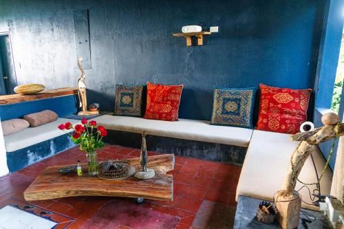 a room with a bench with pillows and a table at Aldea Sabatinga in Manizales