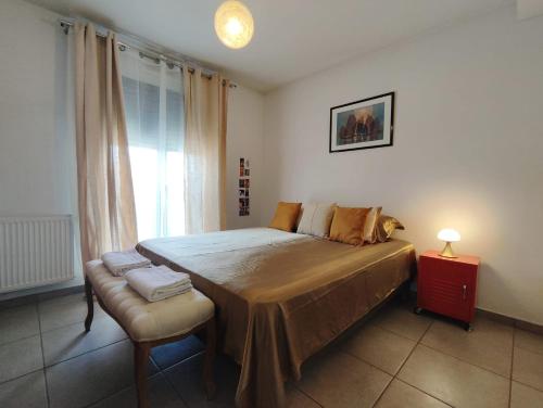 une chambre avec un lit avec une chaise et une fenêtre dans l'établissement Appartement charmant à la Teste de Buch, à La Teste-de-Buch