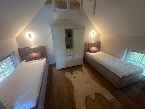 a attic bedroom with two beds and a closet at Pape Rogas in Pape