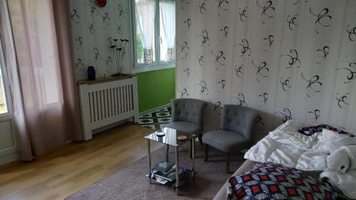 - une chambre avec un lit, 2 chaises et des rideaux dans l'établissement studio 1 pièce principale avec balcon local à vélo privé place dans la rue pour voiture, à Dieppe