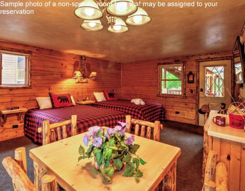 a bedroom with two beds and a table with flowers at Meadowbrook Resort in Wisconsin Dells
