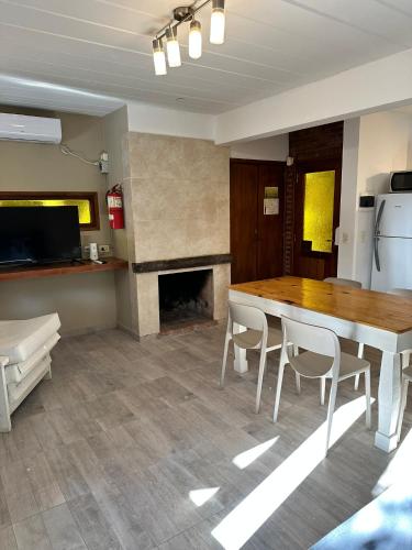 a kitchen with a table and chairs and a fireplace at Kimbara Bosque y Mar in Mar de las Pampas